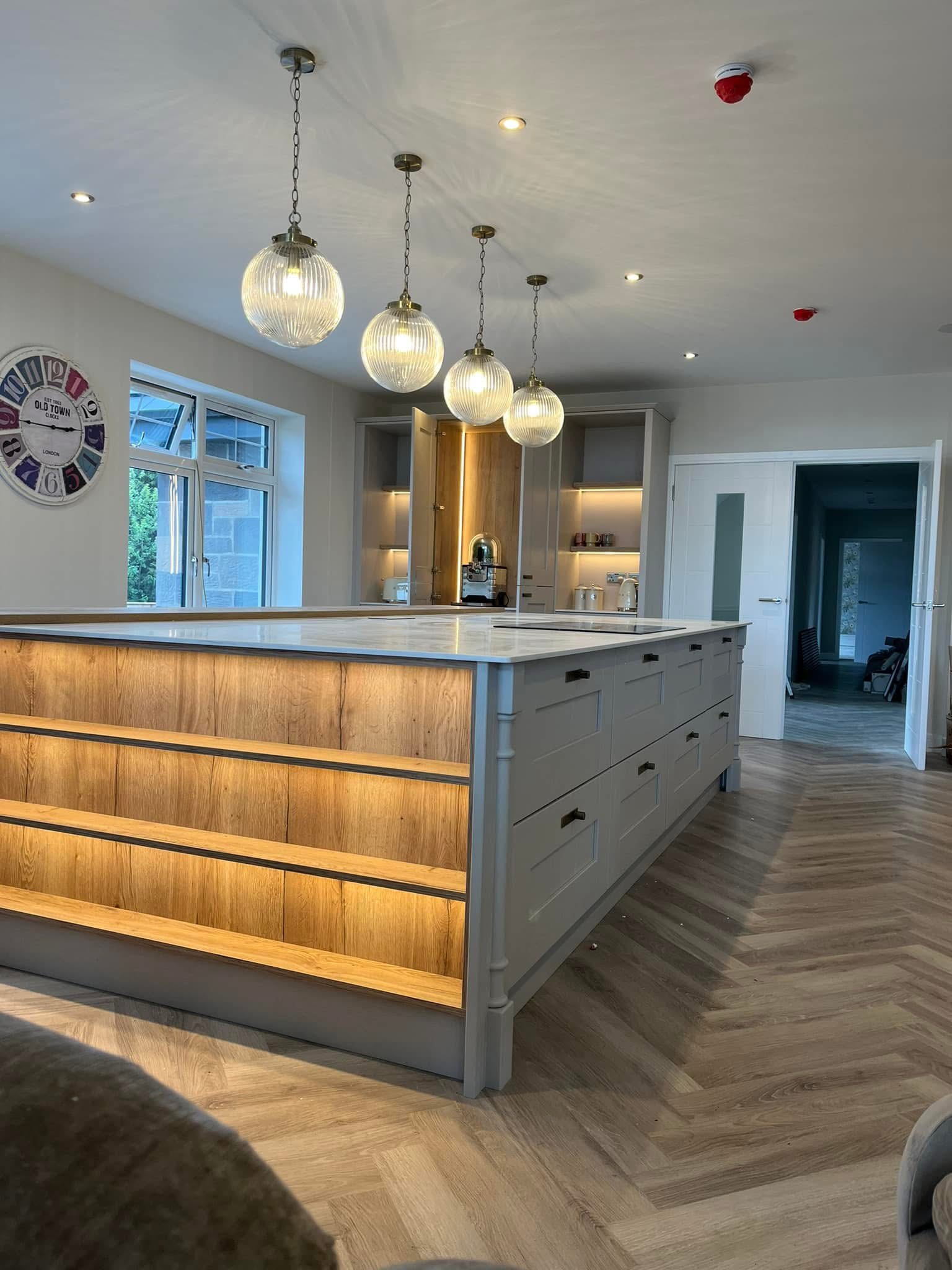 Kitchen island with oak LED shelves and pendant lighting fitted by Nelectrical